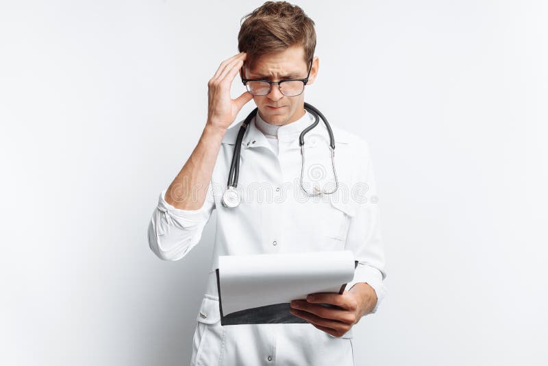 Durchdachter Doktor, die Dokumente betrachtend und macht Anmerkungen in den Dokumenten, ein junger Student mit einem Ordner in se stockbild Durchdachter Doktor, die Dokumente betrachtend und macht Anmerkungen in den Dokumenten, ein junger Student mit einem Ordner in se stockbild