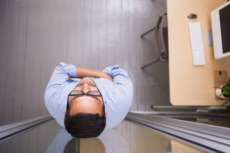 Durchdachter Geschäftsmann, der gegen Glaswand im Büro steht lizenzfreies stockbild Durchdachter Geschäftsmann, der gegen Glaswand im Büro steht lizenzfreies stockbild