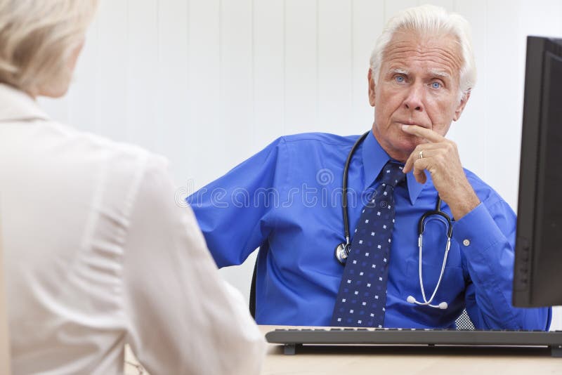 Durchdachter älterer männlicher Doktor With Computer stockbild Durchdachter älterer männlicher Doktor With Computer stockbild