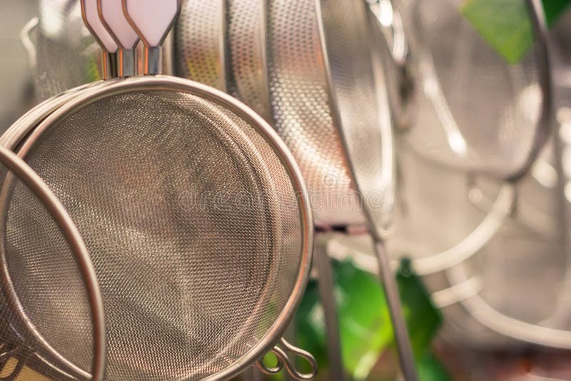 Durchschlagenkeukengerei in de vorm van een kleine steelpan of een emmer met gaten op de bodem stock foto Durchschlagenkeukengerei in de vorm van een kleine steelpan of een emmer met gaten op de bodem stock foto