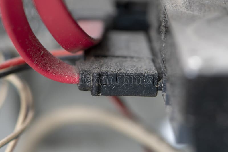 Dusty cables are inserted into the hard drive on the computer. Concept: old hardware, risk of computer ignition, slow down of hard stock images