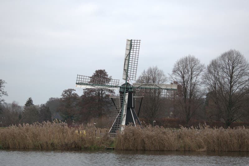 Dutch mill across a river stock images