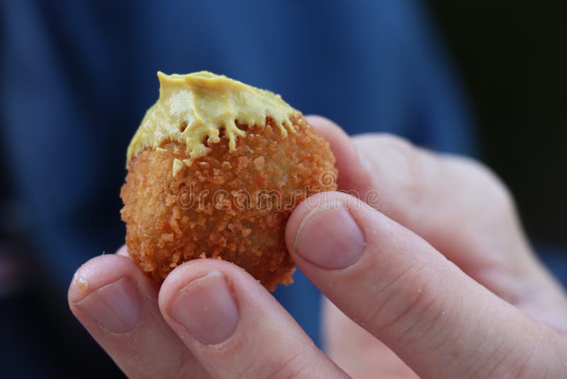 Dutch snack: Man eating a bitterbal