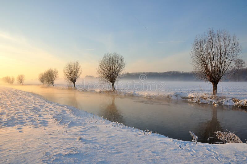Dutch winter landscape with snow and low sun stock photo Dutch winter landscape with snow and low sun stock photo