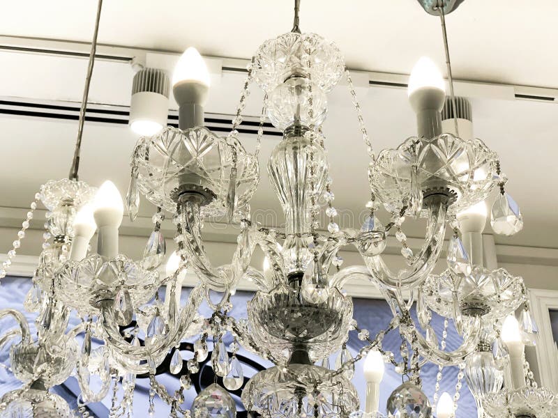 Duur binnenland Grote elektrische die kroonluchter van transparante glasparels wordt gemaakt Wit die plafond met gipspleister het royalty-vrije stock foto Duur binnenland Grote elektrische die kroonluchter van transparante glasparels wordt gemaakt Wit die plafond met gipspleister het royalty-vrije stock foto