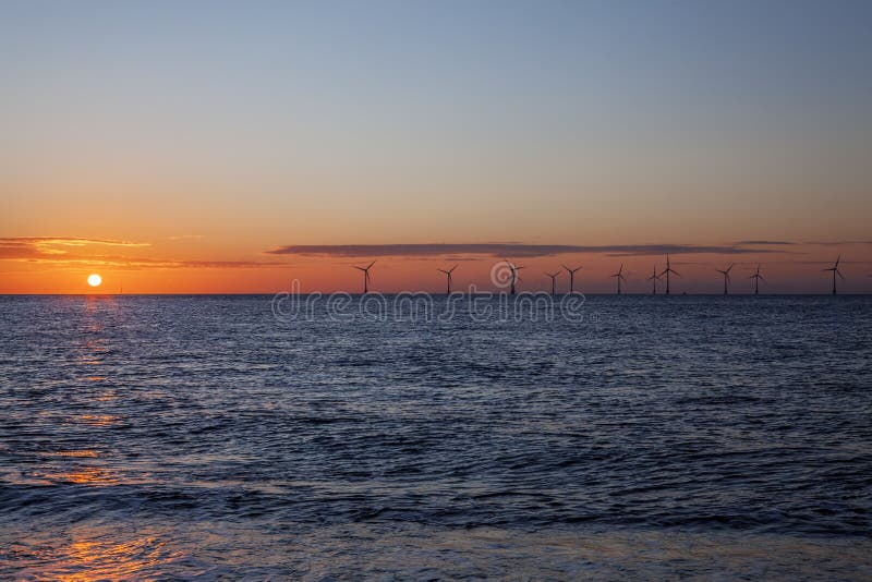 Renewable energy, An offshore wind farm in the red glow of dawn. These turbines caught at sunrise off the East coast of UK although the beautiful red glow looks tropical. Renewable energy, An offshore wind farm in the red glow of dawn. These turbines caught at sunrise off the East coast of UK although the beautiful red glow looks tropical.