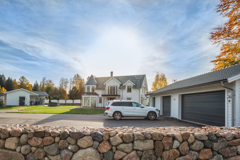 Duży rodzina dom z kopia rozmiaru garażem i samochód parkujący w przodzie Mieszkaniowy dom z betonowym podjazdem i wejściowym drz