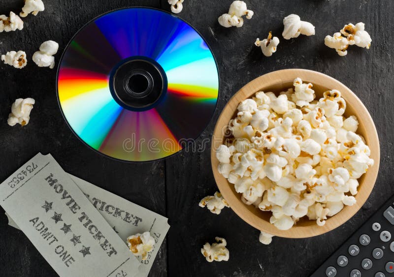 DVD o disco azul de la película del rayo con la TV teledirigida, boletos de la película y cuenco de palomitas en fondo oscuro Pel fotografía de archivo libre de regalías DVD o disco azul de la película del rayo con la TV teledirigida, boletos de la película y cuenco de palomitas en fondo oscuro Pel fotografía de archivo libre de regalías
