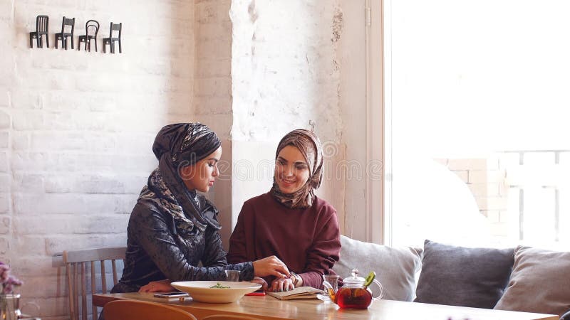 Dwa biznesowej kobiety młody muzułmański obsiadanie w kawiarni biznesowej filiżanki przydatny emisyjny lunch otwierał