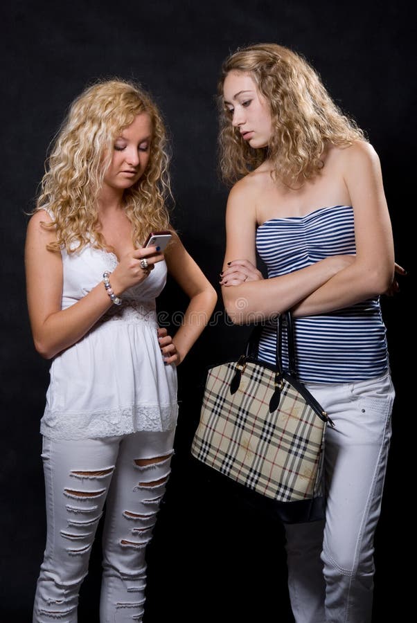 Dwa blondynek spojrzenie w telefon komórkowy obraz stock