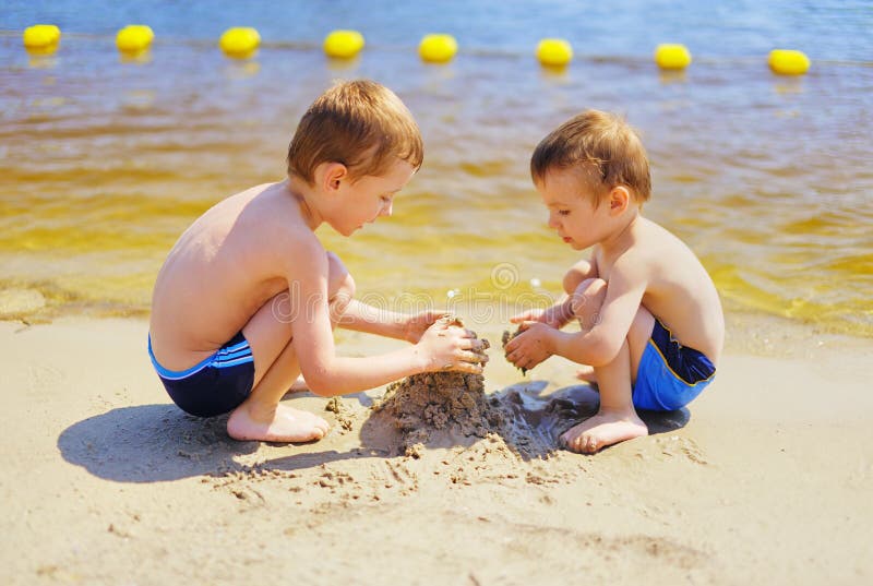 Dwa chłopiec buduje sandcastle na plaży obraz stock Dwa chłopiec buduje sandcastle na plaży obraz stock