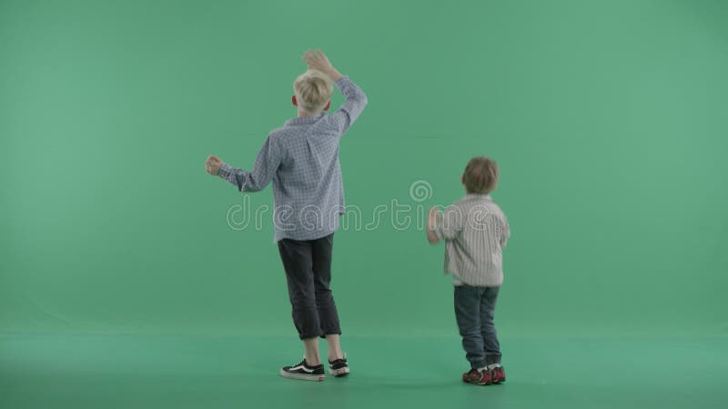 Dwa chłopiec stoją plecy widza i skoku falowania ręki