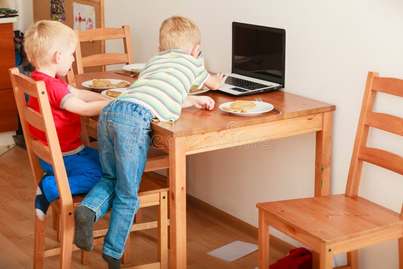 Dwa chłopiec używa laptop bawić się gry fotografia stock Dwa chłopiec używa laptop bawić się gry fotografia stock