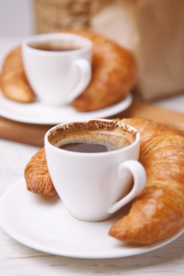Dwa croissants obok one i filiżanki kawy zdjęcie royalty free Dwa croissants obok one i filiżanki kawy zdjęcie royalty free