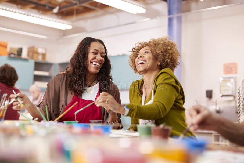 Two Mature Women Attending Art Class In Community Centre Together. Two Mature Women Attending Art Class In Community Centre Together