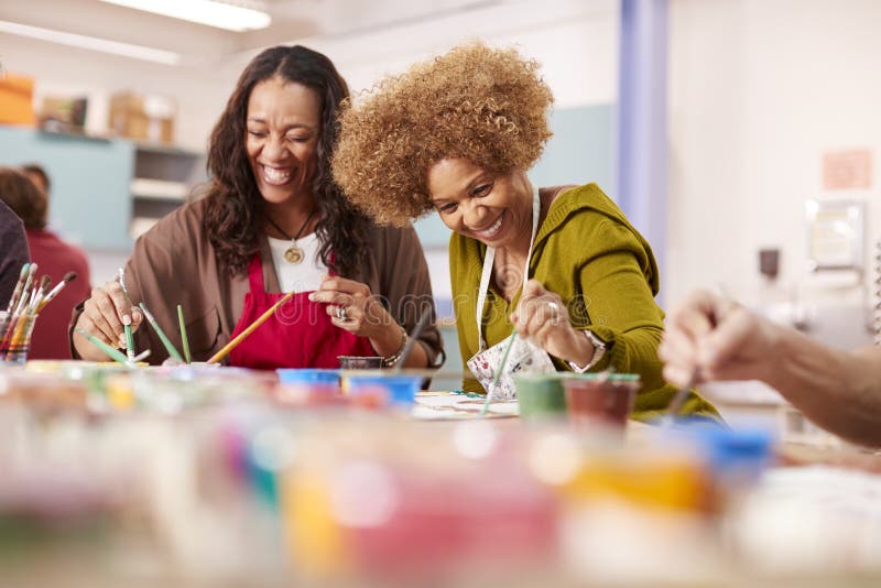 Two Mature Women Attending Art Class In Community Centre Together. Two Mature Women Attending Art Class In Community Centre Together