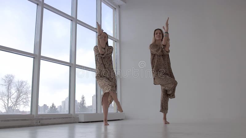 Dwa Europejskiej kobiety robi joga wpólnie i ćwiczy orzeł pozę