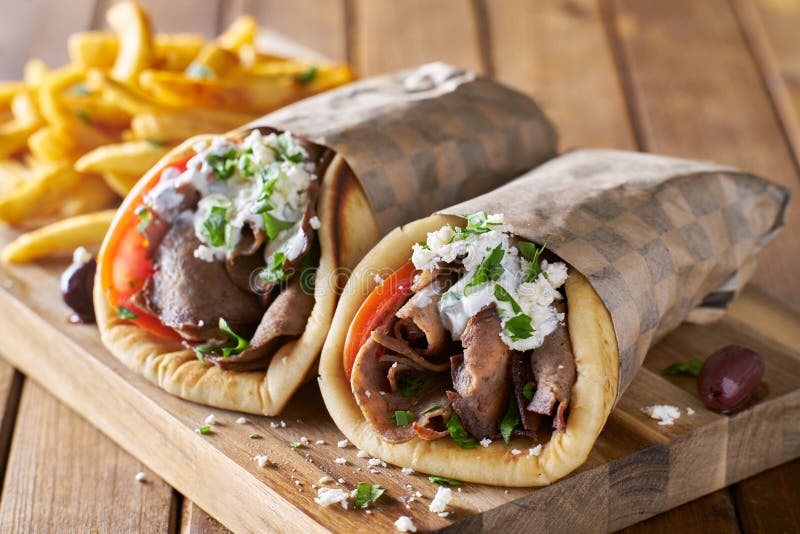Dwa greckiego gyros z ogolonymi baranka i francuza dłoniakami obrazy royalty free Dwa greckiego gyros z ogolonymi baranka i francuza dłoniakami obrazy royalty free