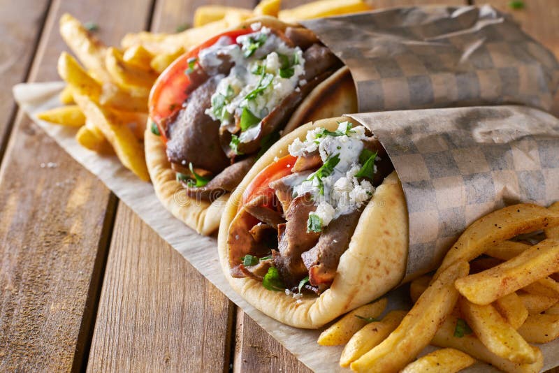 Dwa greckiego gyros z ogolonymi baranka i francuza dłoniakami zdjęcia stock Dwa greckiego gyros z ogolonymi baranka i francuza dłoniakami zdjęcia stock