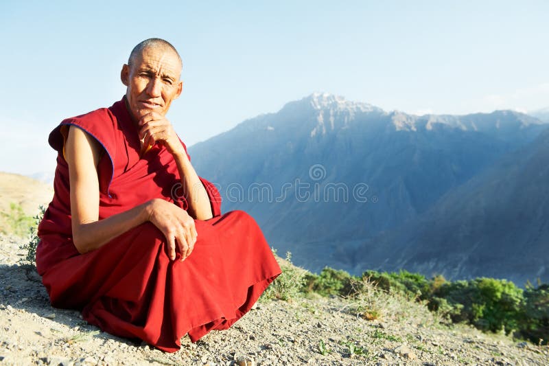 Two Indian tibetan old monks lama in red color clothing sitting in front of mountains. Two Indian tibetan old monks lama in red color clothing sitting in front of mountains
