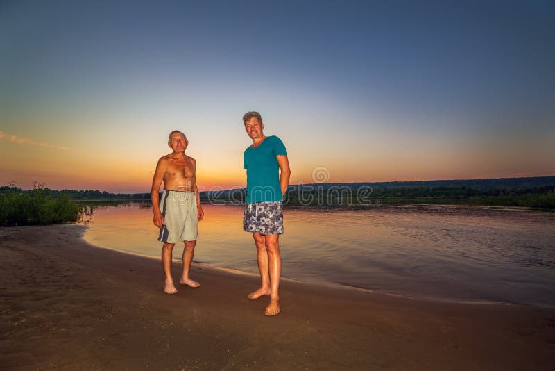 Dwa kamrata na dzikiej plaży rzeka przeciw tÅ‚u zmierzch obrazy royalty free Dwa kamrata na dzikiej plaży rzeka przeciw tÅ‚u zmierzch obrazy royalty free