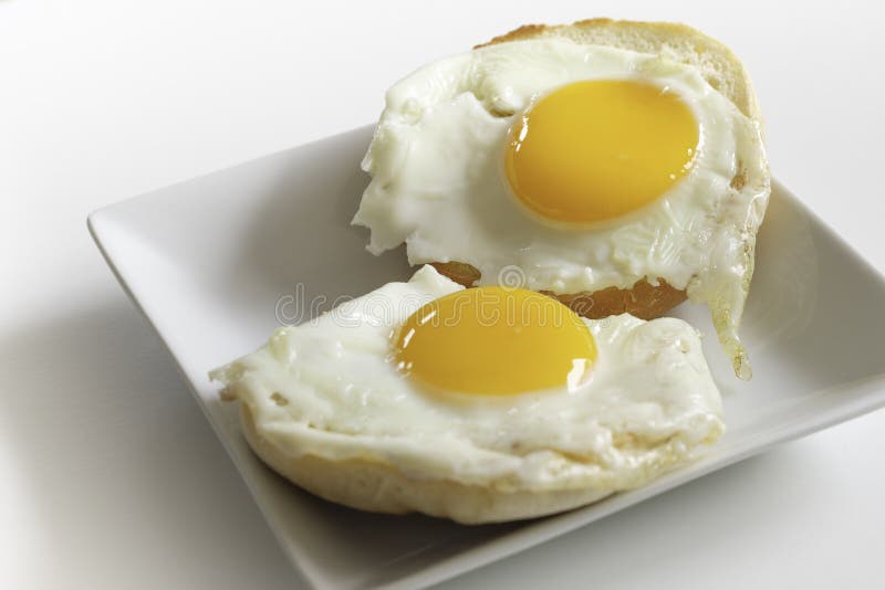 Dwa kawałki smażonych słonecznych jaj bocznych na angielskich muffinach