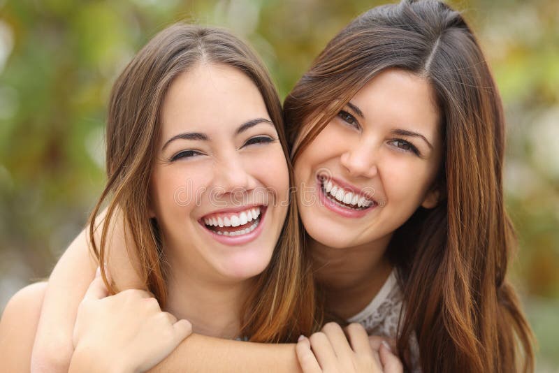 Dwa kobieta przyjaciela śmia się z perfect białych zęby