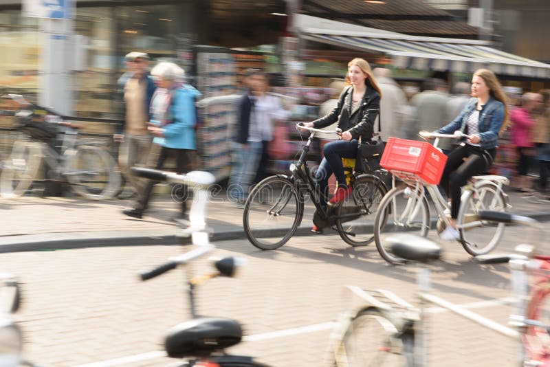 Dwa kobiety jechać na rowerze pracować w Amsterdam miasta ruchu drogowym fotografia royalty free Dwa kobiety jechać na rowerze pracować w Amsterdam miasta ruchu drogowym fotografia royalty free