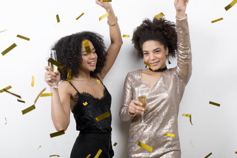 Two trendy women celebrating birthday with champagne and confetti. Two trendy women celebrating birthday with champagne and confetti