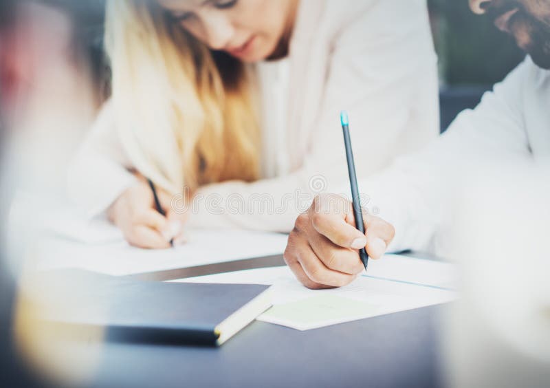 Dwa młodego coworkers pracuje wpólnie w nowożytnym biurze i robi notatkom na dokumentach Zbliżenie pióra mienie w rękach Horyzont obrazy stock Dwa młodego coworkers pracuje wpólnie w nowożytnym biurze i robi notatkom na dokumentach Zbliżenie pióra mienie w rękach Horyzont obrazy stock