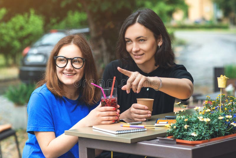 Dwa młodego pięknego kobieta przyjaciela wskazuje na boku kawową przerwę na tarasie, opowiada z each inny obrazy royalty free Dwa młodego pięknego kobieta przyjaciela wskazuje na boku kawową przerwę na tarasie, opowiada z each inny obrazy royalty free