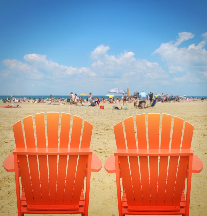 Dwa Pomarańczowego Plażowego krzesła w piasku