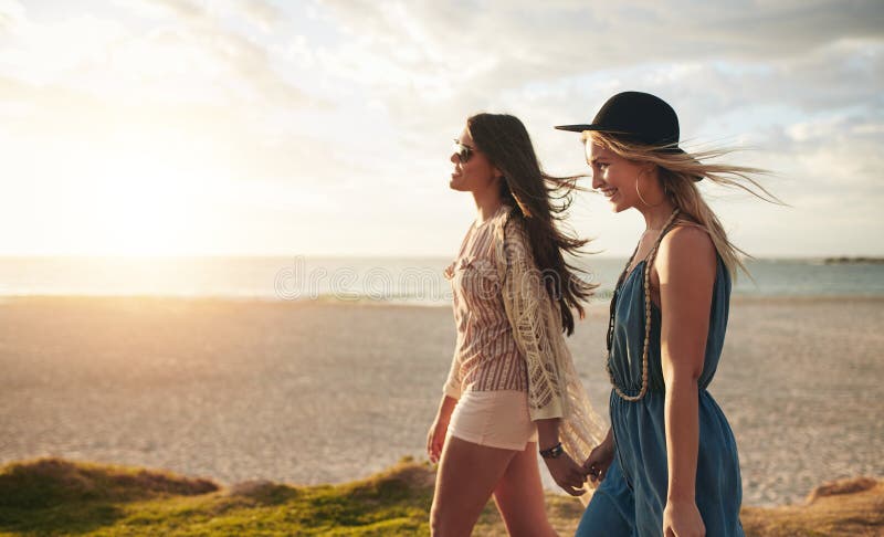 Dwa przyjaciela chodzi na plaży na letnim dniu fotografia stock Dwa przyjaciela chodzi na plaży na letnim dniu fotografia stock