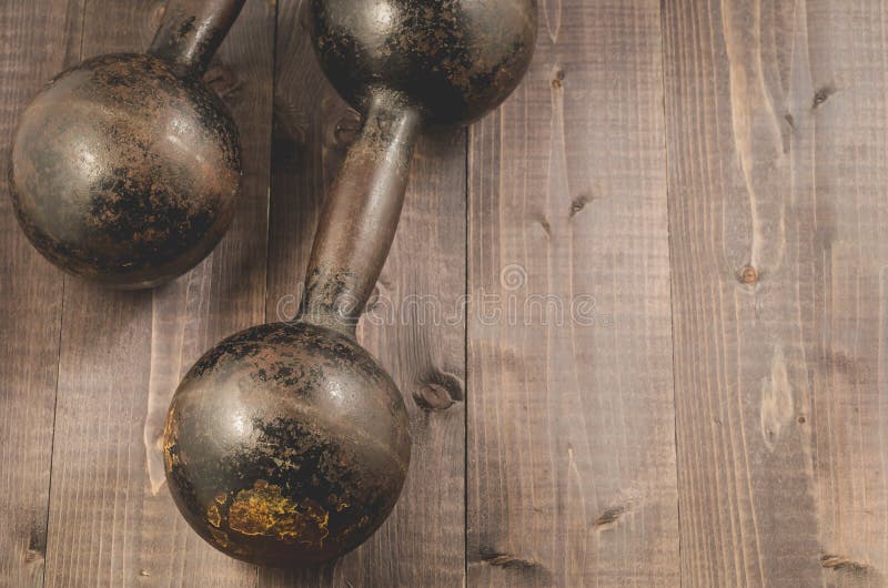 Dwa rocznika dumbbells/Dwa rocznika dumbbells na czerni drewnianym zdjęcie stock Dwa rocznika dumbbells/Dwa rocznika dumbbells na czerni drewnianym zdjęcie stock