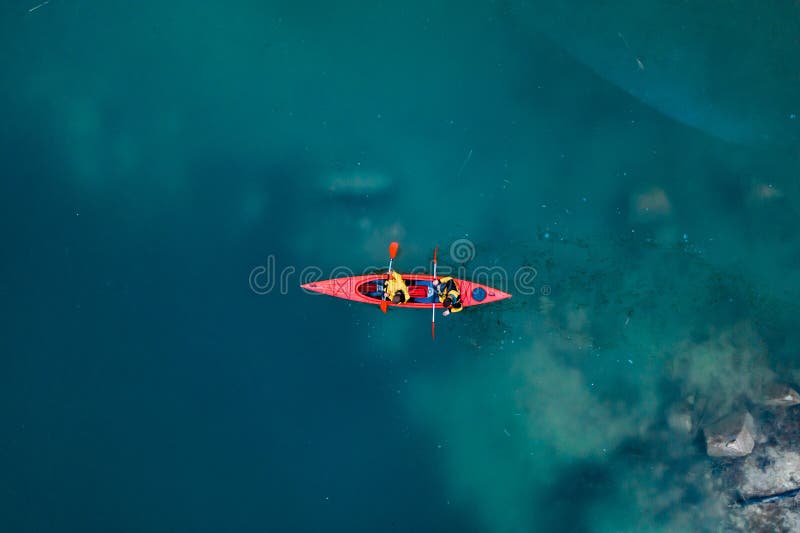 Dwa sportowego m??czyzny p?awika na czerwonej ?odzi w rzece fotografia royalty free Dwa sportowego m??czyzny p?awika na czerwonej ?odzi w rzece fotografia royalty free