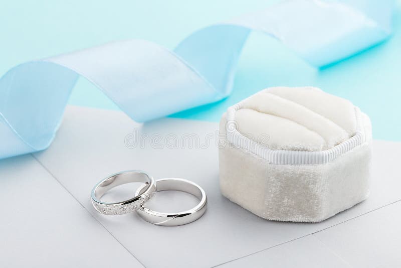 Dwa srebnej obrączki ślubnej z diamentami na błękitnym tle obrazy royalty free Dwa srebnej obrączki ślubnej z diamentami na błękitnym tle obrazy royalty free