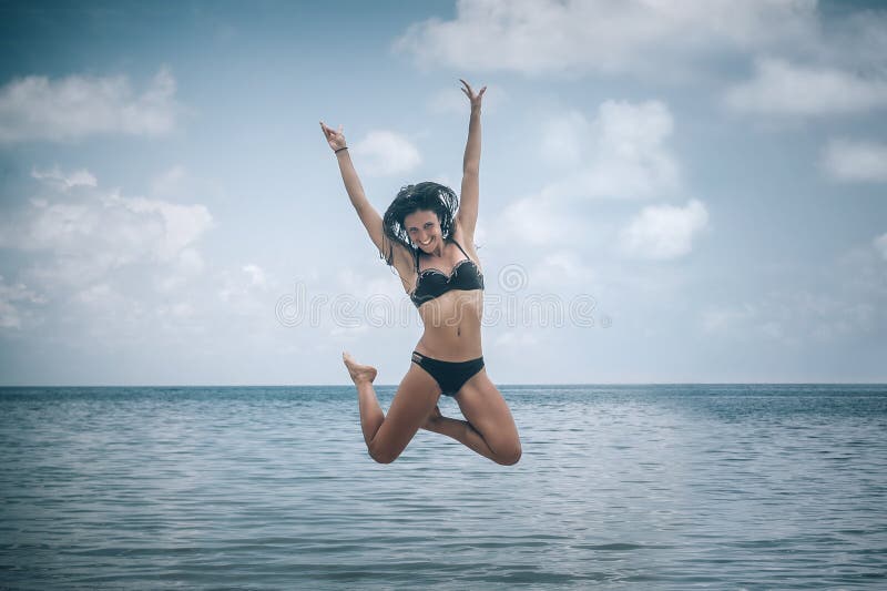 Dwa szczęśliwej dziewczyny skacze na tropikalnej plaży obraz royalty free Dwa szczęśliwej dziewczyny skacze na tropikalnej plaży obraz royalty free