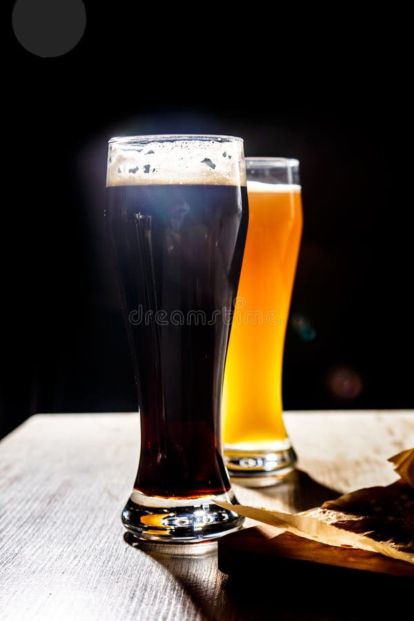 Dwa szkła piwna pozycja na stole na ciemnym tle c fotografia royalty free