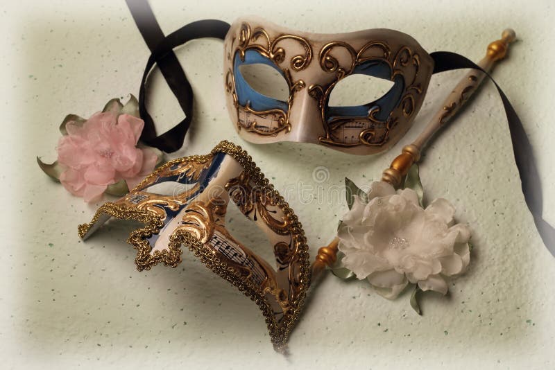 Two Venetian masks with artificial flowers. Two Venetian masks with artificial flowers.