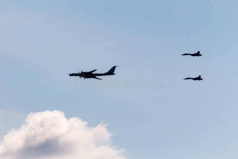 dwa wojownika eskortują Tupolev Tu-95mc, rosjanin strategiczne bombowiec obraz stock dwa wojownika eskortują Tupolev Tu-95mc, rosjanin strategiczne bombowiec obraz stock