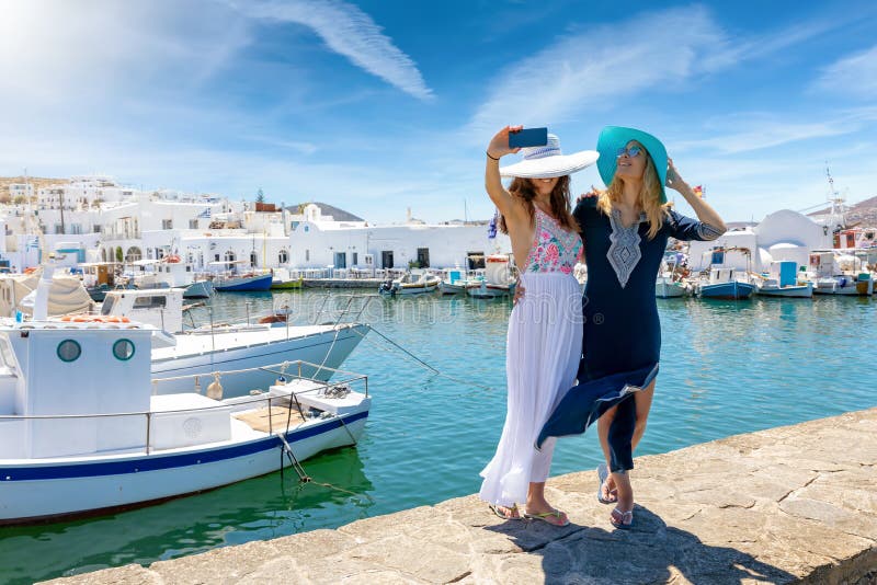 Dwa żeńskiego przyjaciela bierze selfie fotografie przy wioską rybacką Naousa obraz royalty free Dwa żeńskiego przyjaciela bierze selfie fotografie przy wioską rybacką Naousa obraz royalty free