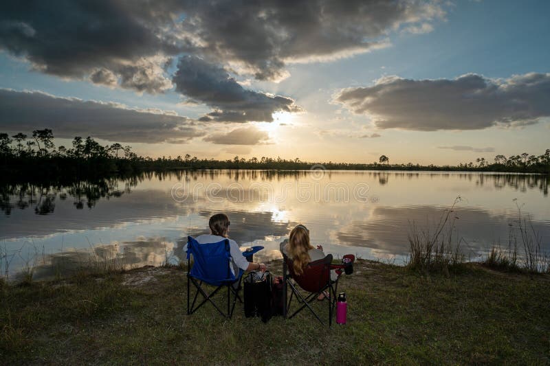 Dwie kobiety lubią zachód słońca w sosnowym jeziorze w parku narodowym everglades. zdjęcia royalty free