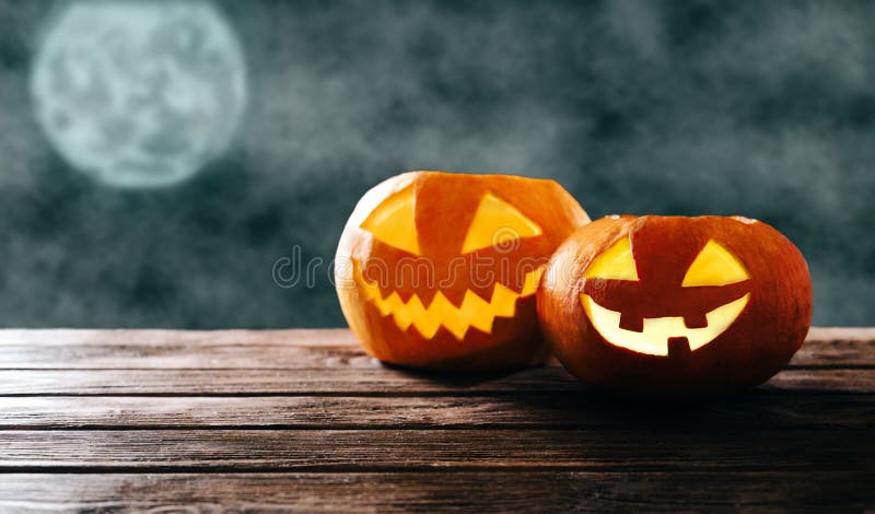 Dwie połyskujące dynie Halloween w ciemnej nocy zdjęcia stock Dwie połyskujące dynie Halloween w ciemnej nocy zdjęcia stock