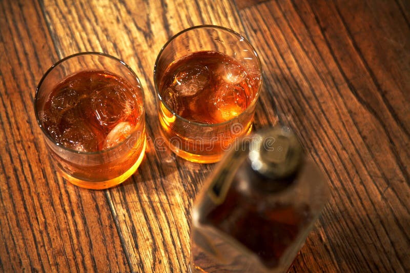 Two glasses from whisky and a bottle on a wooden table. Two glasses from whisky and a bottle on a wooden table