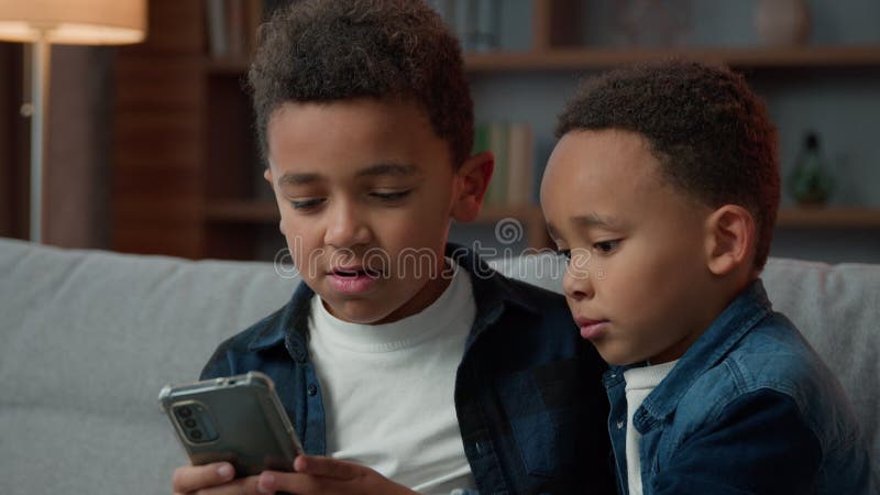 Dwoje rodzeństwa amerykański amerykański bracia synowie dzieci chłopcy przyjaciele małe dzieci w domu przy użyciu telefonu komórko