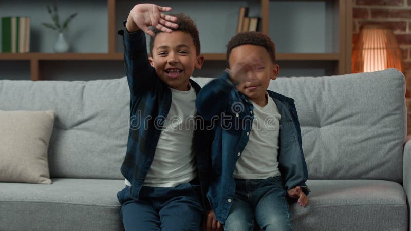 Dwoje śmiesznych, cudownych, afrykańskich dzieci adoptowanych przez dzieci sierota chłopcy rodzeństwo siedzące razem w kanapie w d