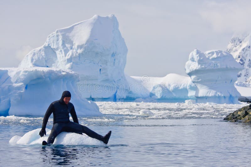 Diver on the ice against the blue iceberg. Antarctica. Diver on the ice against the blue iceberg. Antarctica