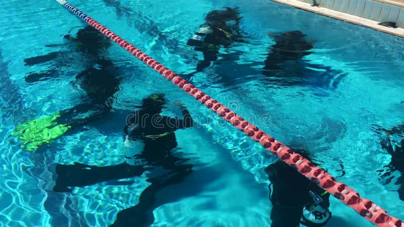 Dykare som utövar undervattensdykning i en simbassäng