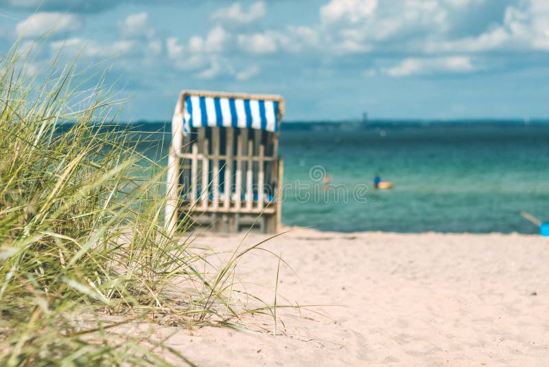 Dyn med några gräs och traditionella trästrandstolar på den sandiga stranden Nordlig Tyskland, på kusten av baltiskt fotografering för bildbyråer Dyn med några gräs och traditionella trästrandstolar på den sandiga stranden Nordlig Tyskland, på kusten av baltiskt fotografering för bildbyråer