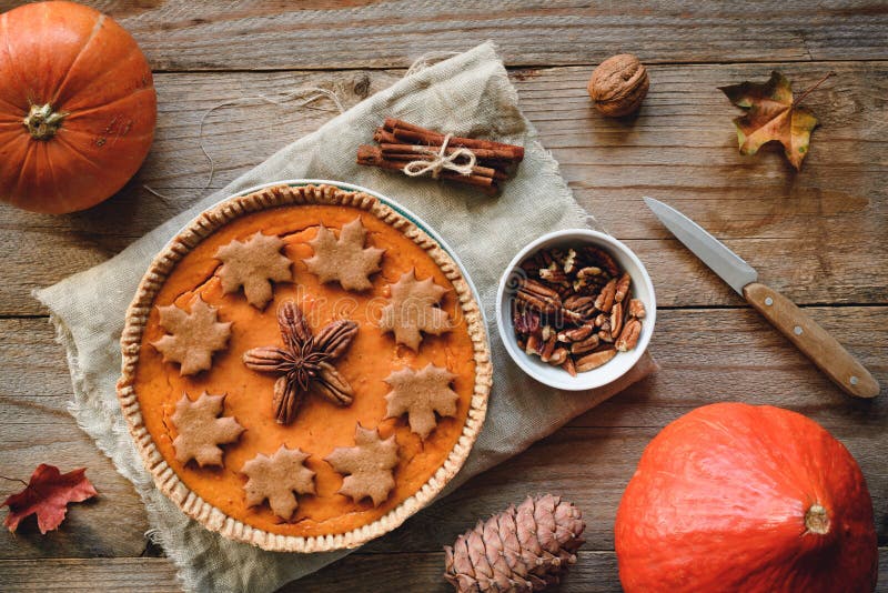 Dyniowy kulebiak z pecan dokrętkami na drewnianym tle zdjęcie stock Dyniowy kulebiak z pecan dokrętkami na drewnianym tle zdjęcie stock